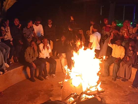 A group gathered around the bonfire at night