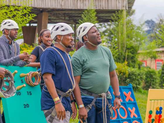 Colleagues in harnesses next to giant outdoor board games