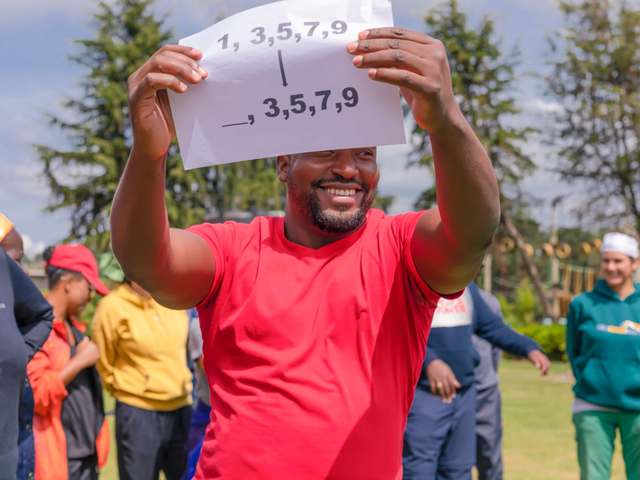 A guest holding up a number-puzzle clue during a treasure hunt